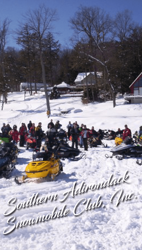 group of snowmobiles parked on a snowy hill